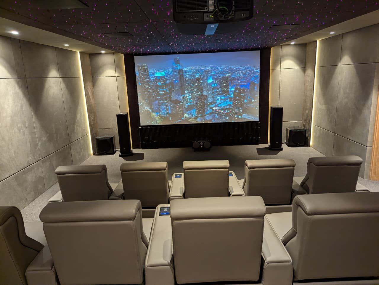 Looking toward the Project Platinum screen from the recliners, with a star ceiling and flanking speakers